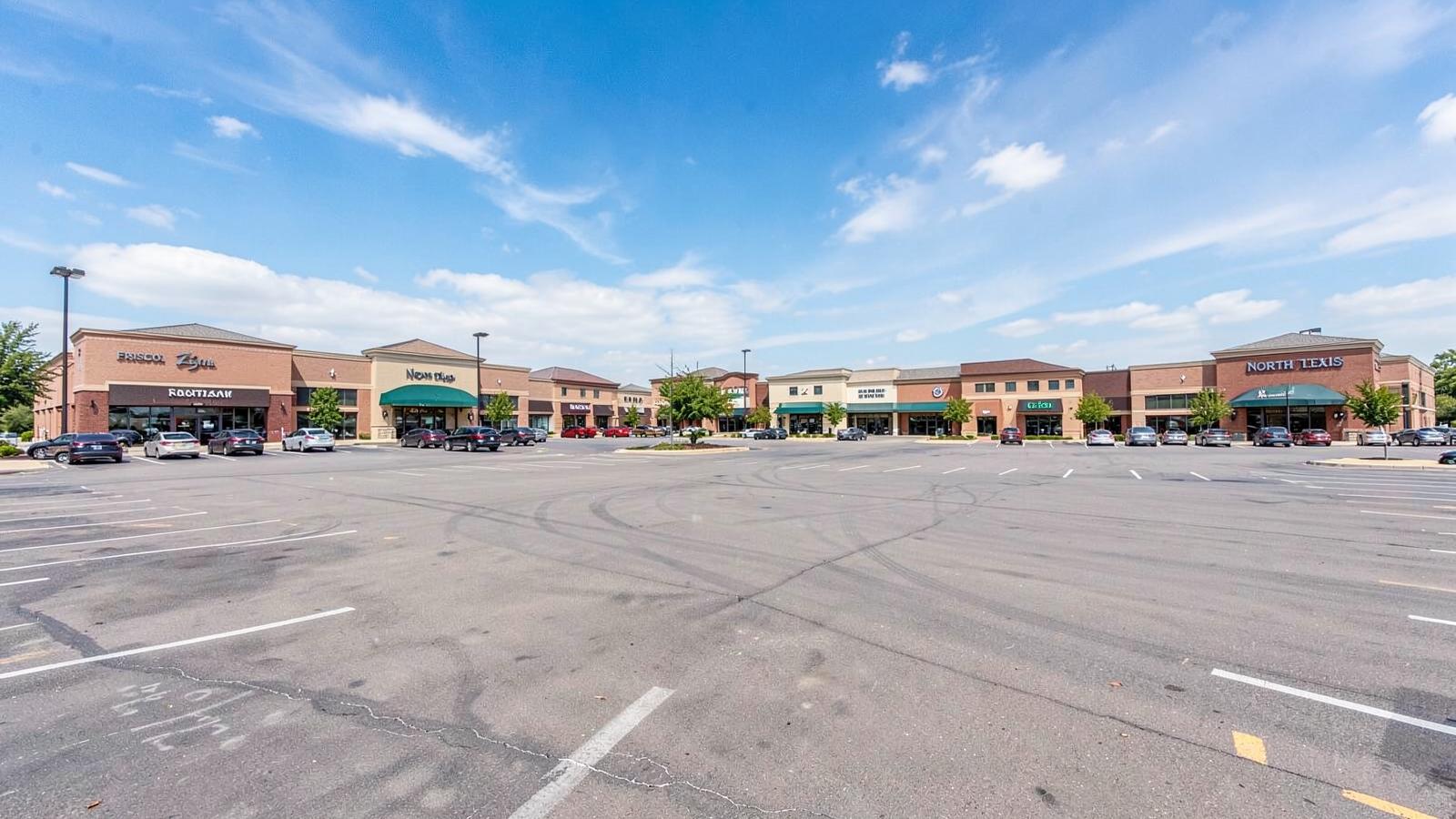 A North Texas retail centre with open surface parking under a big sky