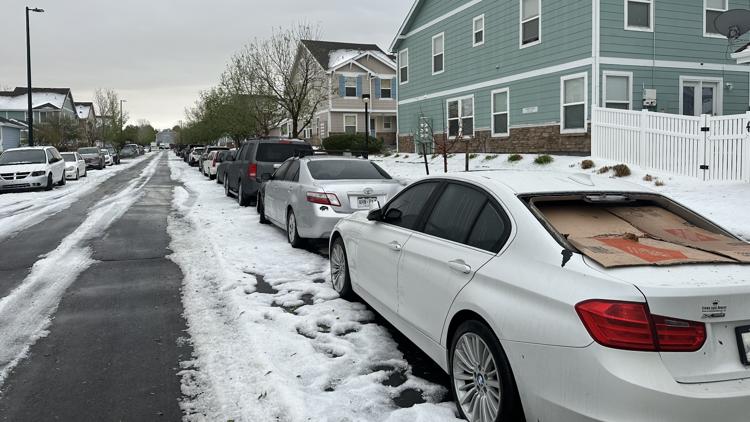Hail-covered Dallas-Fort Worth neighborhood street with damaged vehicles parked after a Texas hail storm