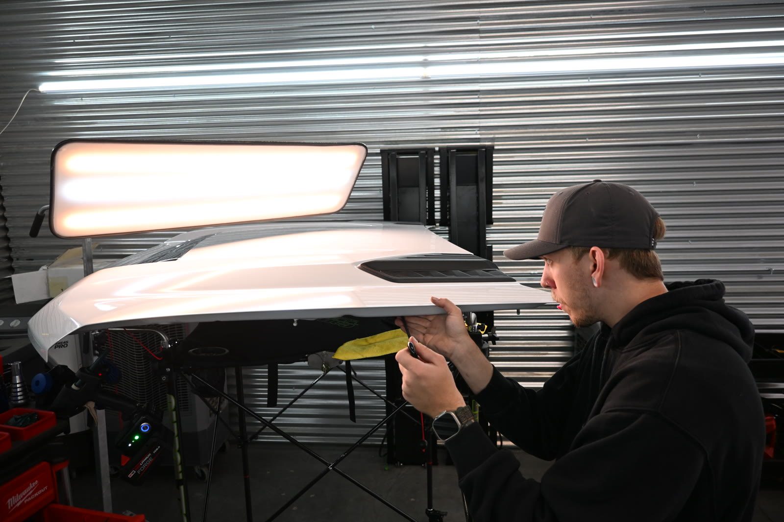 DFW Paintless Dent Repair technician working a dent out from behind the panel